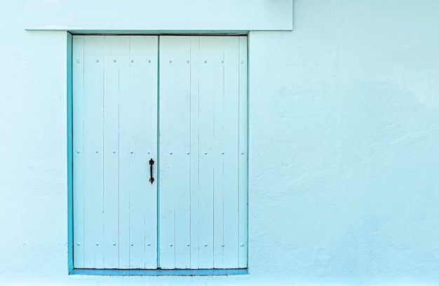 Façade de maison bleue avec porte bleue traditionnelle, avec espace de copie