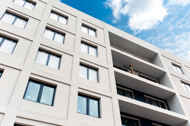 La façade de la maison en construction avec balcon et enduit décoratif coloré