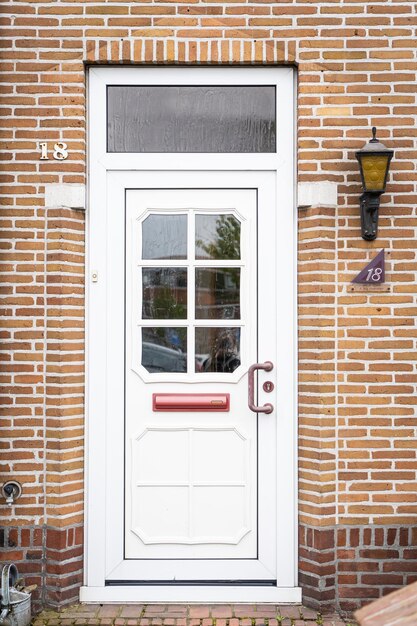 Façade d'une maison hollandaise typique avec des murs de briques, des marches, des portes et des fenêtres, des portes sur la rue aux Pays-Bas