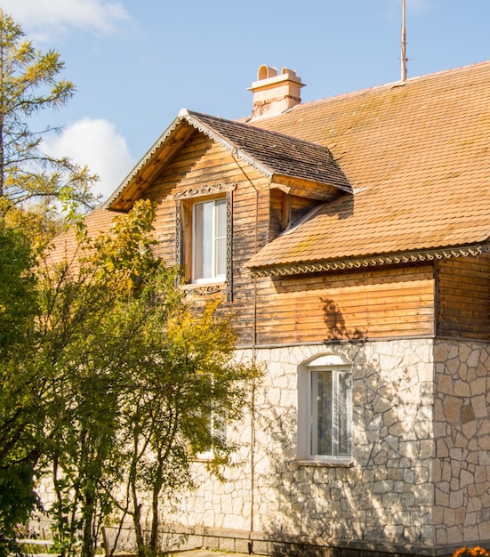 Photo la façade d'une maison en pierre à deux étages avec un grenier et un toit de tuiles brunes