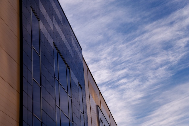 La façade moderne de l'immeuble de bureaux est un fragment abstrait, avec des fenêtres brillantes dans une structure en acier. Grand fond pour une carte de visite, un dépliant, une bannière avec un espace pour une inscription ou un logo