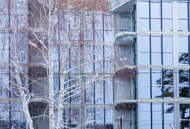 La façade en verre d'appartements résidentiels dans un immeuble de grande hauteur. Fenêtres et balcons dans la conception d'un immeuble moderne.