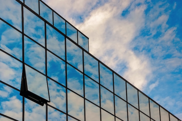 Photo façade en verre d'un centre d'affaires contre un ciel bleu avec des nuages