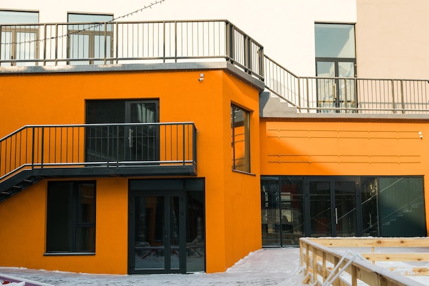 Photo façade d'une vieille maison avec un beau balcon avec de la neige en hiver balcon avec des balustrades métalliques