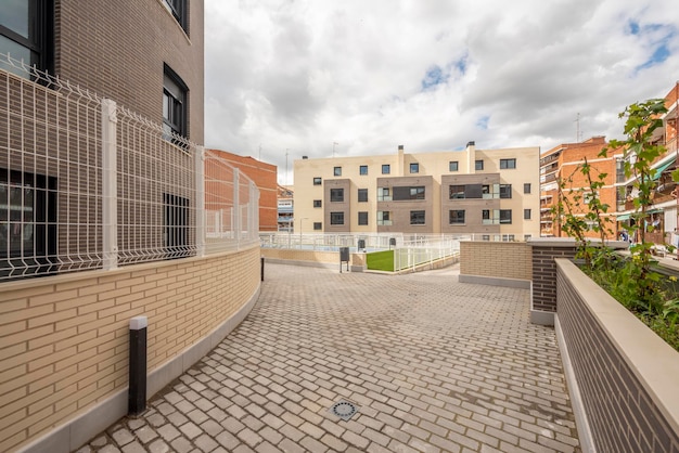 Façades de maisons résidentielles urbaines avec jardins communaux et passerelle avec pavés de granit au sol