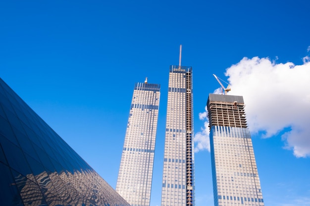 Façades en verre de gratte-ciel par une belle journée ensoleillée avec des rayons de soleil dans le ciel bleu. Économie, finances, concept d'activité de développement commercial. Vue de bas en haut