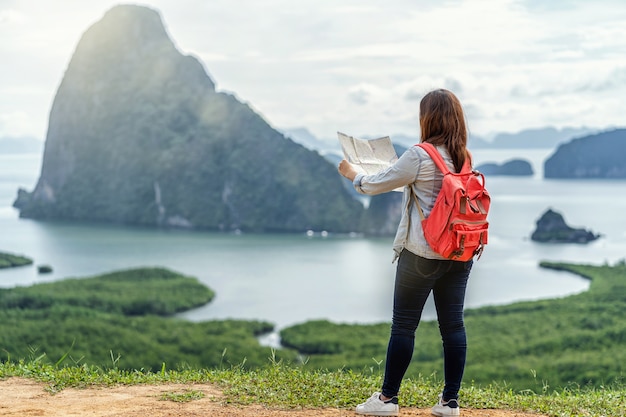 Face arrière d&#39;un voyageur asiatique regardant la carte pour voyager avec un routard chez Fantastic