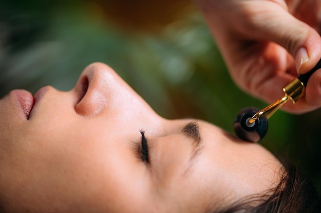 Face Roller Femme massant le visage avec un rouleau à la maison