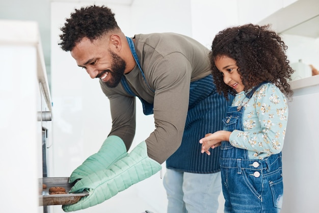 Facile à faire. Photo recadrée d'un beau jeune homme et de sa fille cuisinant dans la cuisine à la maison.