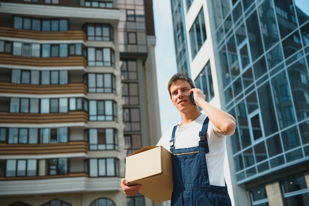 Facteur avec boîte à colis. Service de livraison postale.