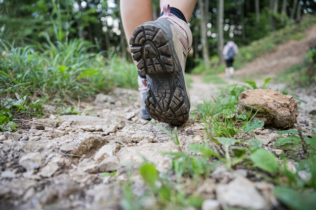 Faible angle de vue du pied féminin marchant sur le sentier de montagne