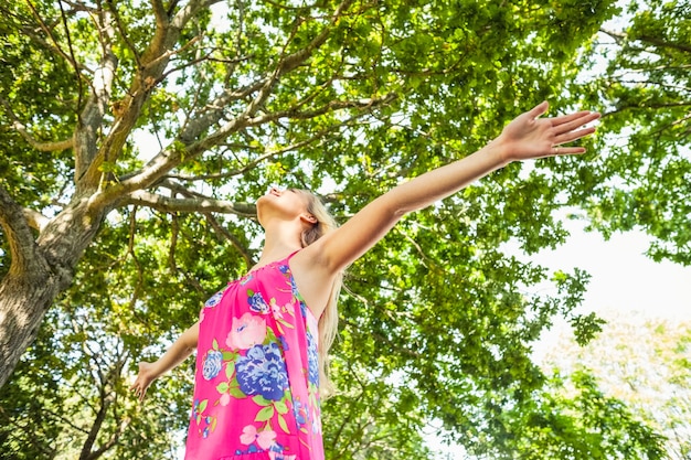 Faible angle de vue de la jeune femme blonde debout sur une pelouse