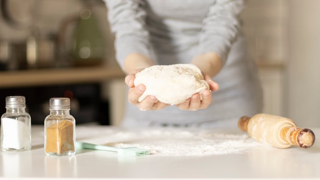 Faire des biscuits de Pâques, des mains féminines avec de la pâte