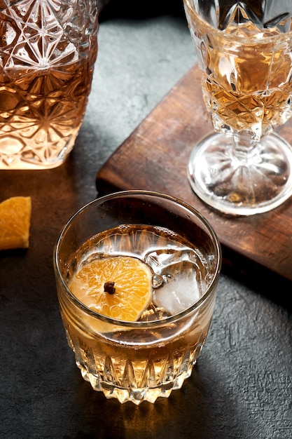faire une boisson avec du whisky orange et du miel, cocktail de fruits sur une base noire rustique