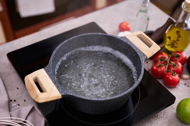 Faire bouillir de l'eau dans une marmite et une casserole sur une cuisinière à induction dans la cuisine domestique