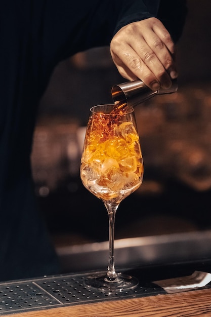 Photo faire un cocktail verre avec de la glace préparation étape par étape du cocktail travail du barman spiritueux à l'orange