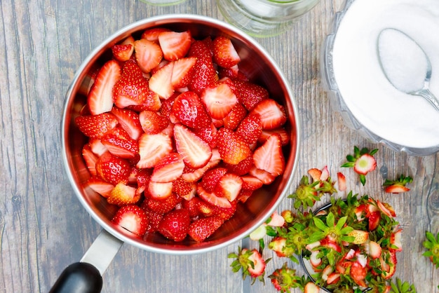 Faire de la confiture commence par nettoyer et couper des fraises fraîches