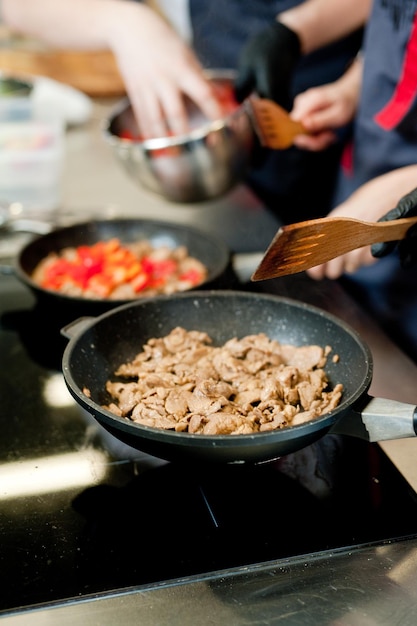 Faire cuire la viande de frites dans une poêle avec des légumes