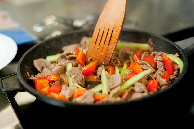 Faire cuire la viande de frites dans une poêle avec des légumes