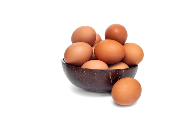 Faire dorer les œufs de poule crus dans une tasse sur fond blanc. Fond de nourriture.