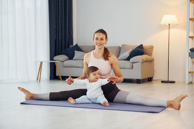 Faire du fitness ensemble Mère avec sa petite fille est à la maison ensemble