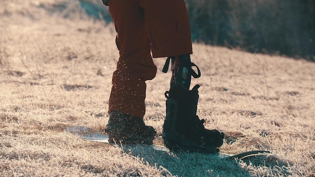 Faire du snowboard un homme avec une jambe prothétique debout sur la planche jambe blessée