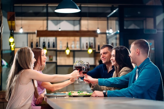 Faire la fête dans un restaurant. Des amis s'amusent dans un restaurant et boivent du vin. Ambiance festive.