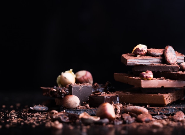 Faire fondre du chocolat ou du chocolat fondu avec un tourbillon de chocolat et empiler, des chips et de la poudre sur une table noire