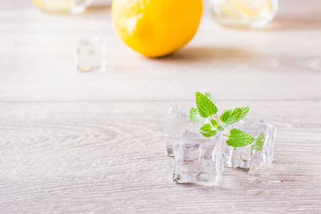 Faire fondre des glaçons et des feuilles de menthe fraîche sur une table en bois