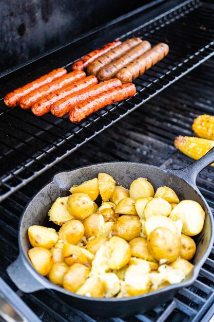 Faire frire de petites pommes de terre dorées dans une poêle en fonte sur un gril à gaz extérieur.