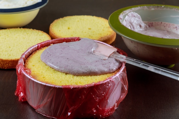 Faire un gâteau. Crème de myrtille et gâteau rond éponge.