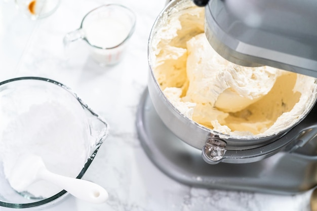 Faire un glaçage à la crème au beurre pour décorer un gâteau à la vanille.