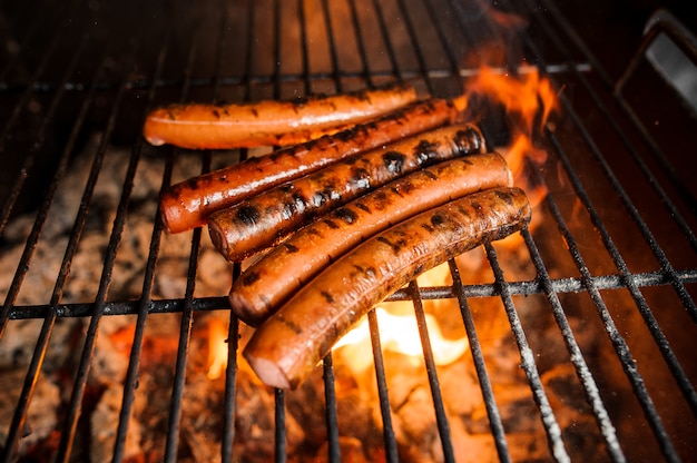 Faire griller des saucisses sur le gril du barbecue. Mise au point sélective