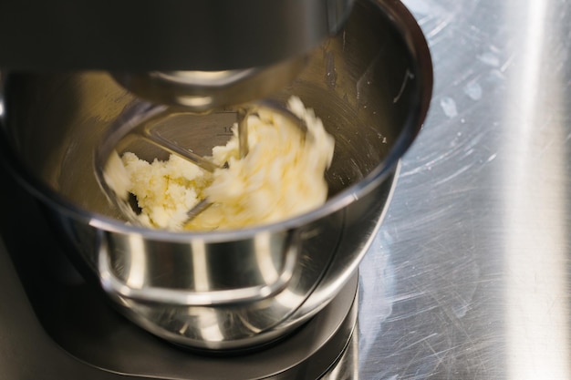 Faire des macarons Un mélangeur de table de cuisine en argent pétrit la pâte pour les macarons