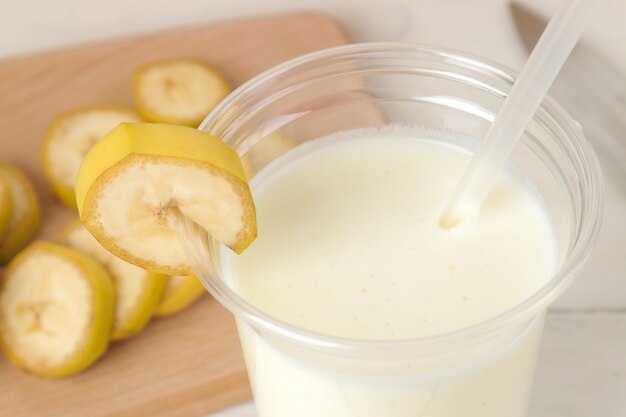 Faire un milk-shake. verre jetable en plastique avec un milk-shake à la banane. fermer