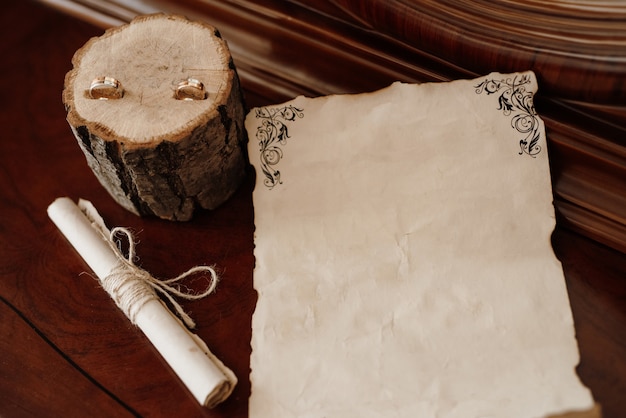 Faire-part de mariage dans une enveloppe grise sur une table avec des brins verts