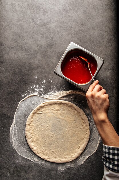 Faire une pizza saupoudrée de sauce tomate sur la pâte