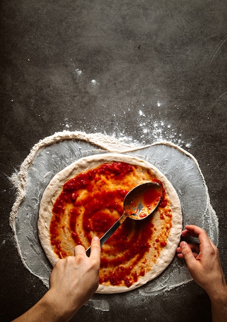 Faire une pizza à tartiner de sauce tomate sur la pâte