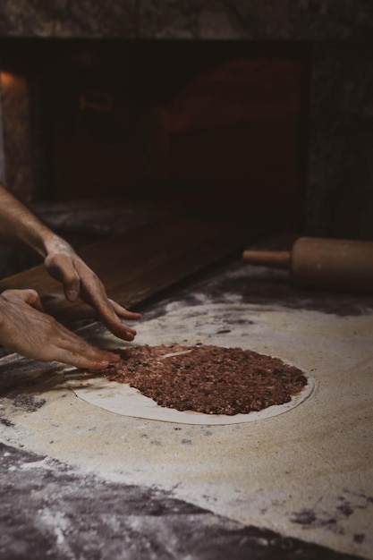 Faire une pizza turque ou un fast-food lahmacun et une cuisine de rue populaire dans les pays méditerranéens