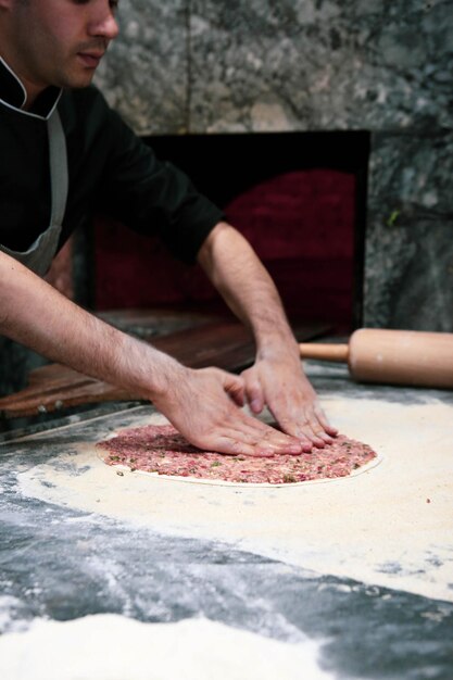 Faire une pizza turque ou une restauration rapide lahmacun et une cuisine de rue populaire dans les pays méditerranéens D