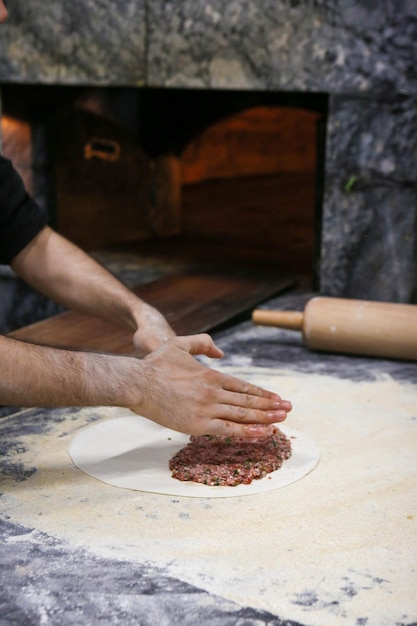 Faire une pizza turque ou une restauration rapide lahmacun et une cuisine de rue populaire dans les pays méditerranéens D