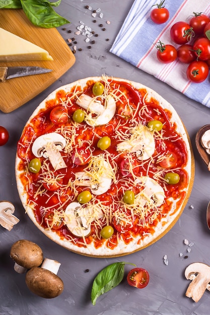 Faire des pizzas faites maison avec des champignons, des tomates et du fromage