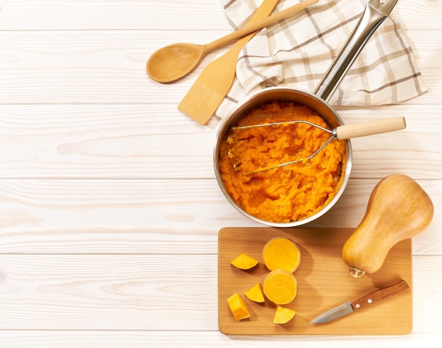 Faire de la purée de courge musquée sur un espace de copie de table en bois blanc pour la vue de dessus de texte