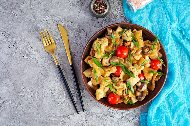 Faire sauter les pâtes avec les légumes, le chou-fleur et les champignons. Vue de dessus