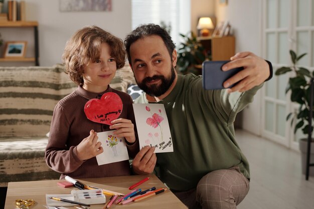 Faire un selfie avec des cartes postales faites à la main