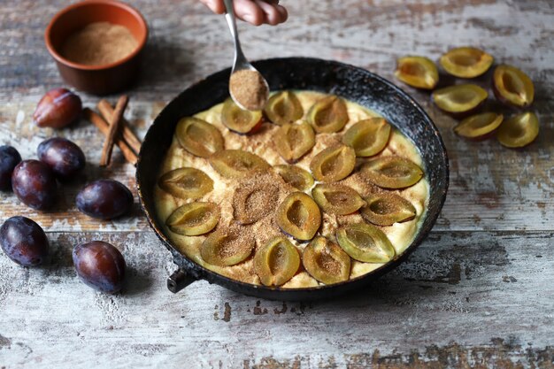 Faire une tarte aux prunes avec du sucre et de la cannelle.