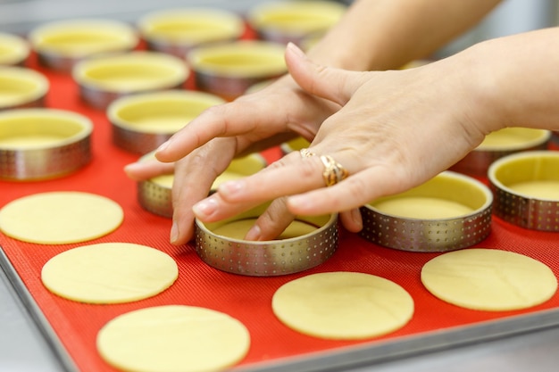 Faire des tartes et quiches sucrées ou salées. Cuisine maison nationale française. Fait main. Formation en cuisine. Le cuisinier remplit le plat de cuisson avec la garniture. Couper les garnitures pour tarte et quiche.