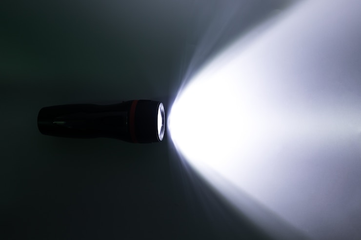 Photo faisceau d&#39;une lampe de poche sur un fond blanc