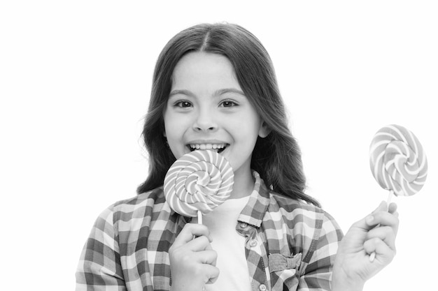 Fait impressionnant sucre nutrition Petite fille souriante tient des bonbons sucette Petite fille avec sucette a l'air heureux Concept de nutrition et de régime sain Concept de dent sucrée Bébé visage heureux mange sucette