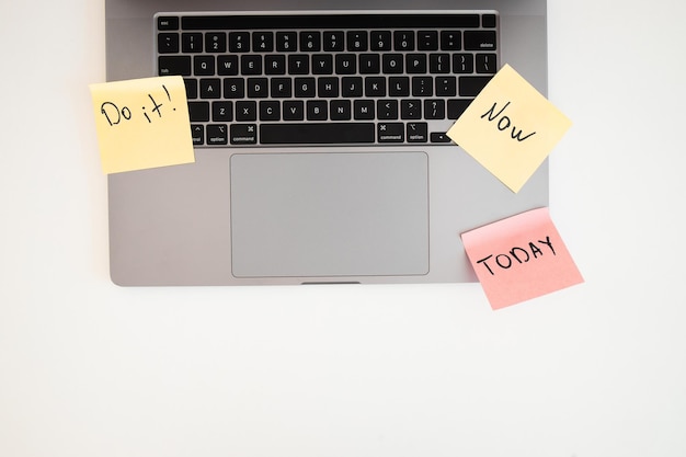 Faites-le maintenant Un message écrit conceptuel sur des notes autocollantes près d'un ordinateur portable sur un tableau blanc Phrases de motivation